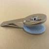 Silver round handheld embosser insert tool on beige background.