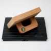 Angled view of large rectangular wooden rubber stamp on black ink pad