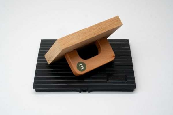 Angled view of large rectangular wooden rubber stamp on black ink pad