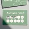Wooden rubber stamp beside printed loyalty card design on green background.