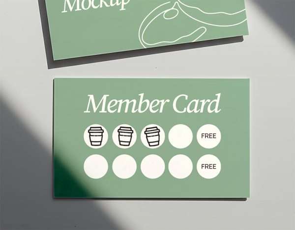 Wooden rubber stamp beside printed loyalty card design on green background.