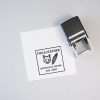 Self-inking logo stamp placed beside a printed square logo on white paper.