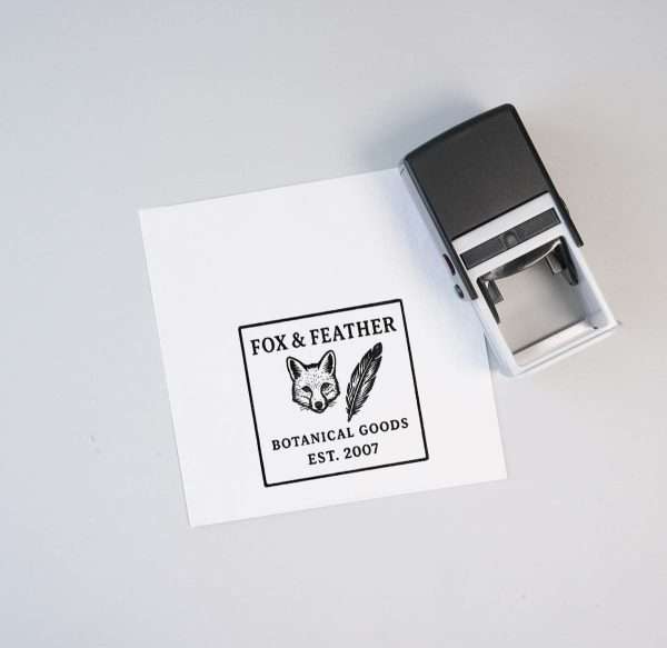 Self-inking logo stamp placed beside a printed square logo on white paper.