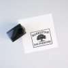 Signature self-inking stamp positioned next to a printed custom logo on white paper.