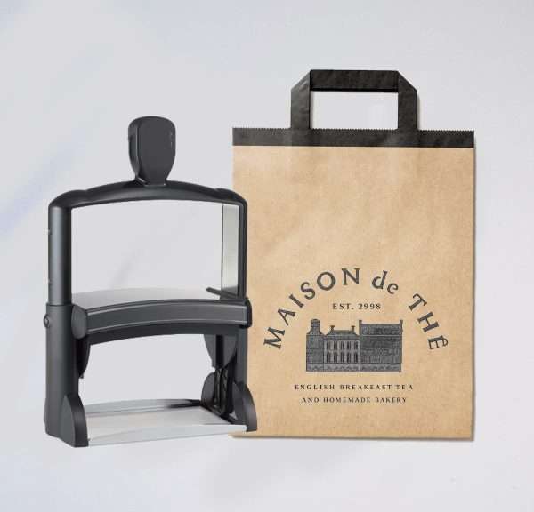 Large signature self-inking stamp with kraft paper pag on white background.